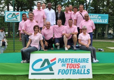 Cécile Lacourt, assise, première à gauche, est ici en compagnie de Marcel Desailly et de l'équipe organisatrice de la finale nationale du Mozaïc Foot Challenge à Clairefontaine, issue des Caisses régionales...